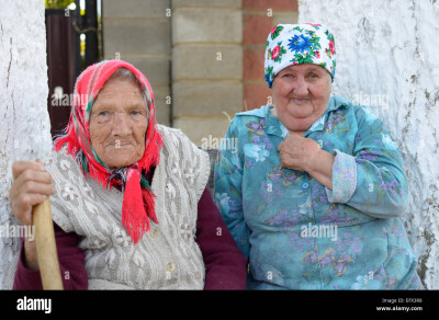 portrait of two old russian women sitting near house between two an EFX3R8
